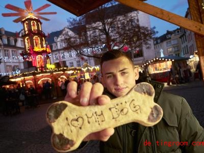  Verkäufer Nino zeigt auf dem Koblenzer Weihnachtsmarkt einen Keks-Knochen für Hunde. Foto: Thomas Frey/dpa 